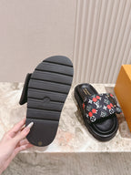 Louis Vuitton slide sandals with textured black outsole and heel tread.