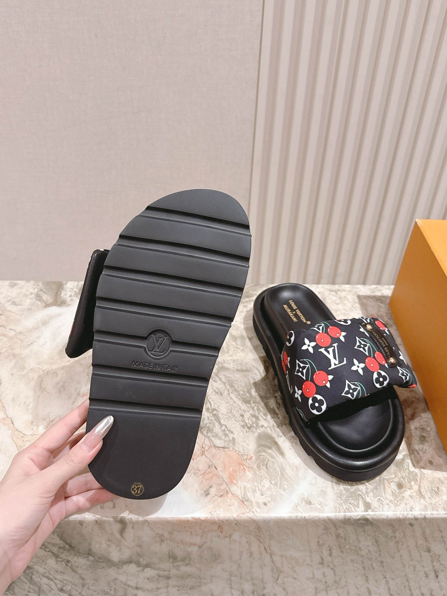 Louis Vuitton slide sandals with textured black outsole and heel tread.