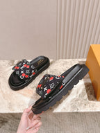 Louis Vuitton slide sandals, black with multicolor monogram strap and rugged sole.