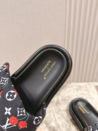 Louis Vuitton slide sandals with black footbed showing embossed brand text.