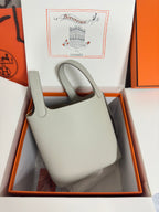 Hermes pale gray leather tote bag in box, front view with handle cutouts