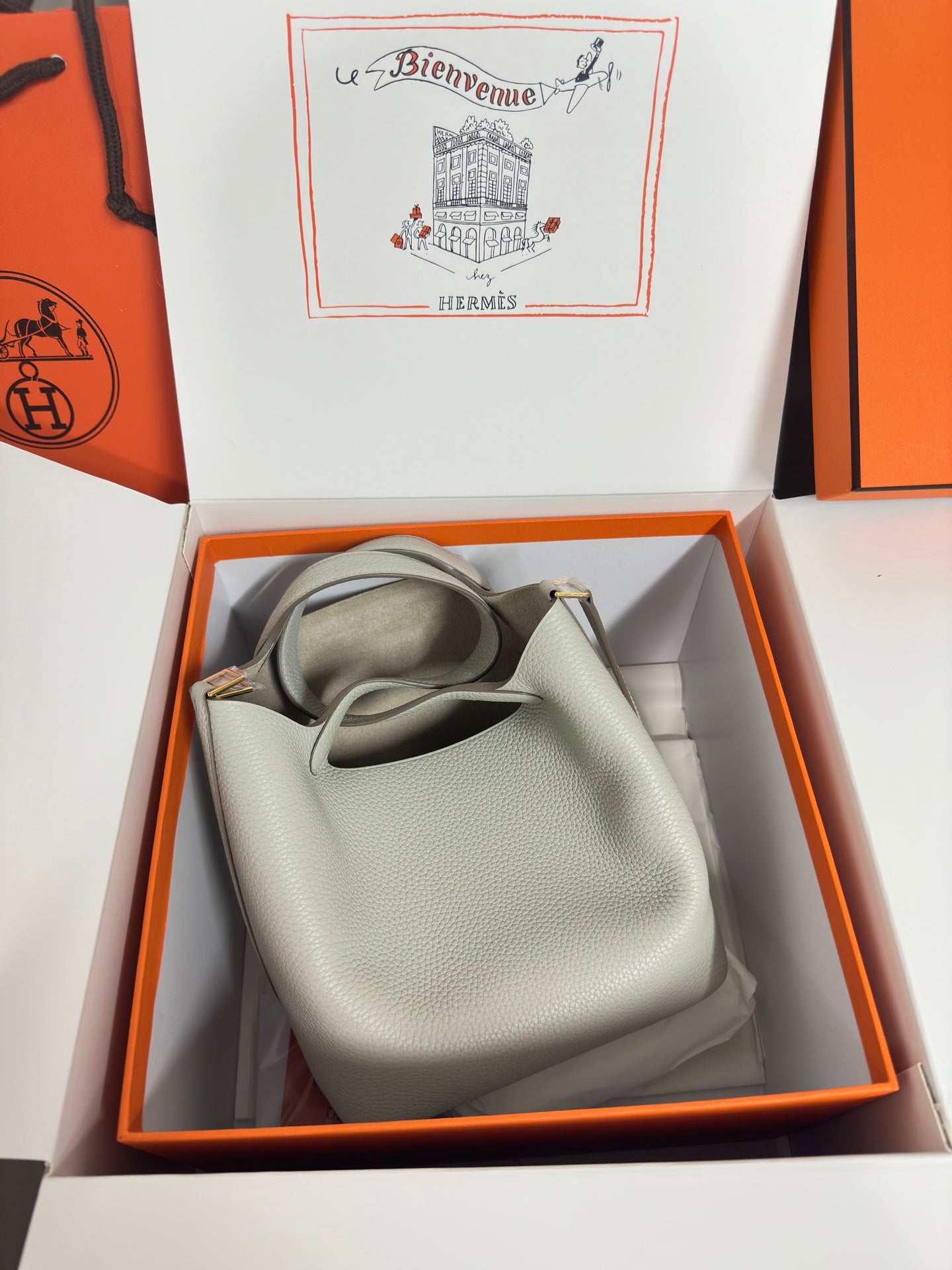Hermes pale gray leather tote bag laid in box, shown with top handles