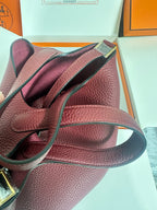 Burgundy textured leather bag with shoulder strap and gold-tone hardware