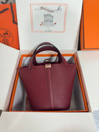 Burgundy textured leather tote bag with center front seam and top handles