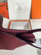 Burgundy textured leather tote strap with gold-tone buckle and fabric lining