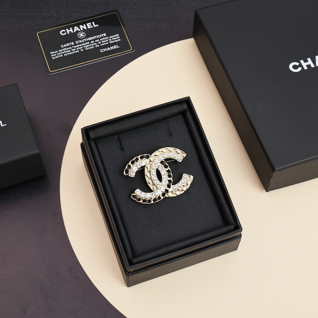 Gold-tone crystal brooch with interlocking C motif, displayed on black cushion