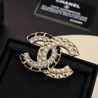 Gold-tone brooch with pearl and clear crystal embellishments, interlocking C design
