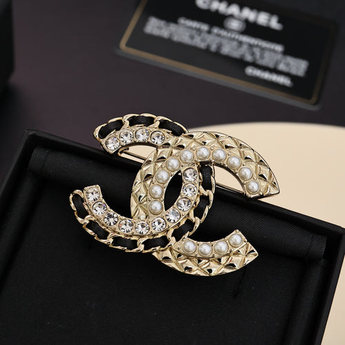 Gold-tone brooch with pearl and clear crystal embellishments, interlocking C design