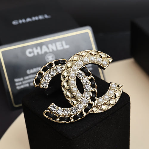 Jeweled gold-tone brooch with pearls and clear crystals, curved interlocking C shape