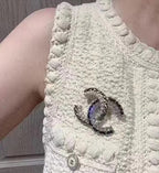Silver-tone brooch with interlocking C, crystal border and deep blue stone accent