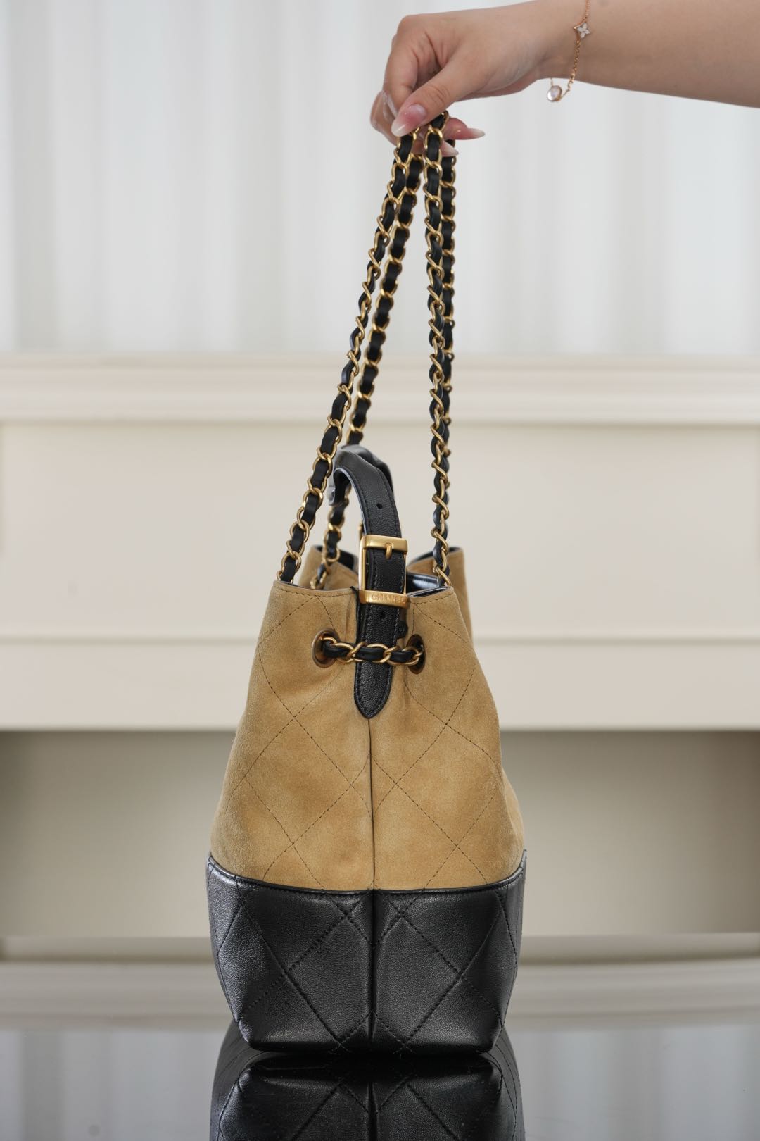 Tan and black quilted shoulder bag with chain straps and gold-tone hardware