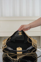 Black quilted bag with chain strap, gold-tone hardware, open top and interior view