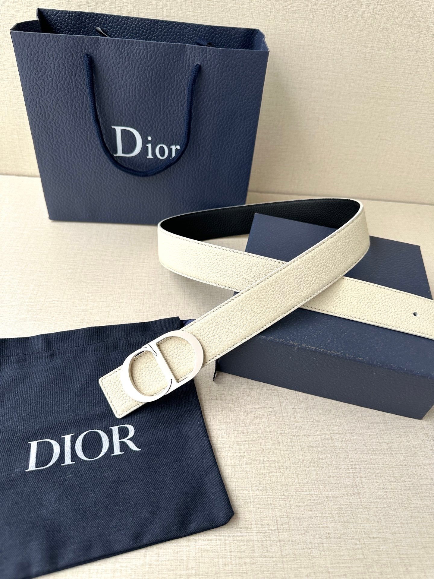 Beige leather Dior belt with oversized logo buckle and adjustable strap