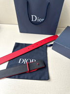 Red leather Dior belt with D buckle, shown on navy dust bag