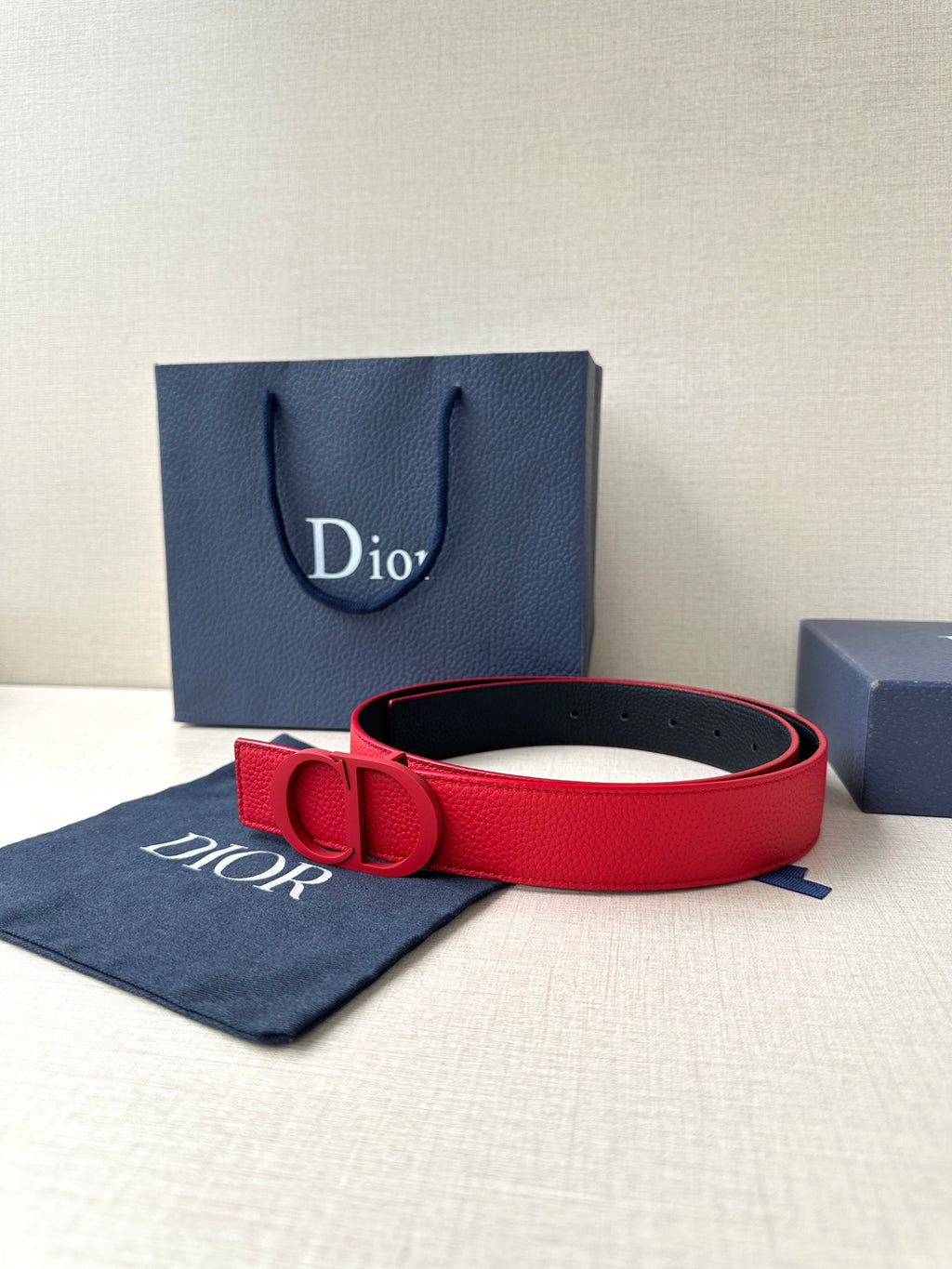 Red leather Dior belt with D buckle, laid with dust bag and box