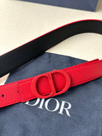 Red leather Dior belt with embossed Dior buckle close-up