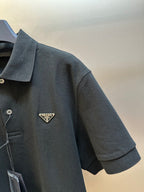 Prada dark polo shirt sleeve with small triangular logo patch