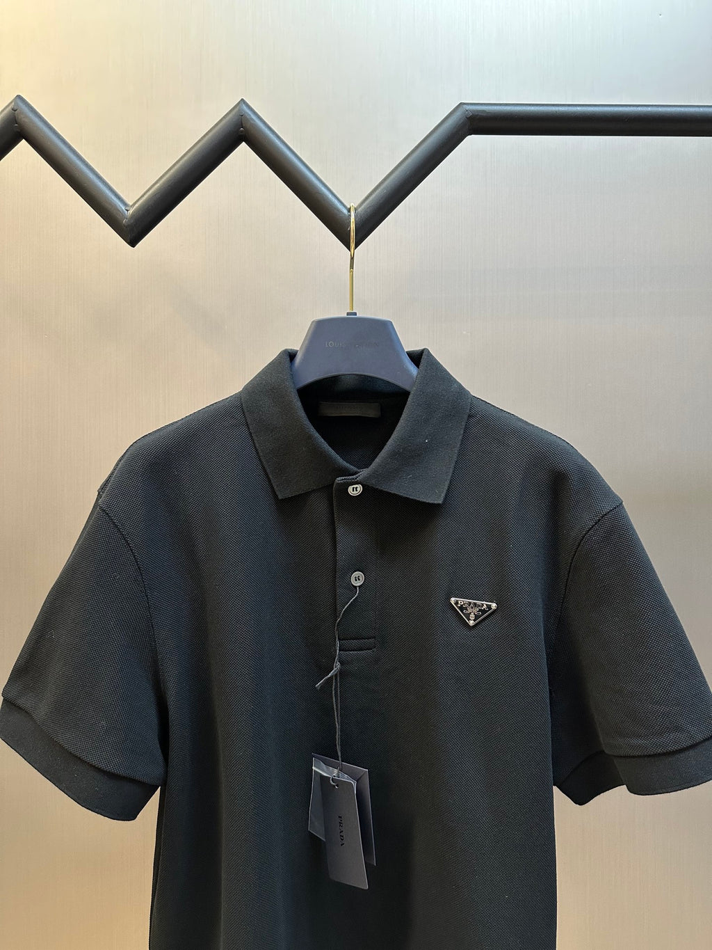 Prada dark polo shirt with spread collar, buttons, and triangular logo
