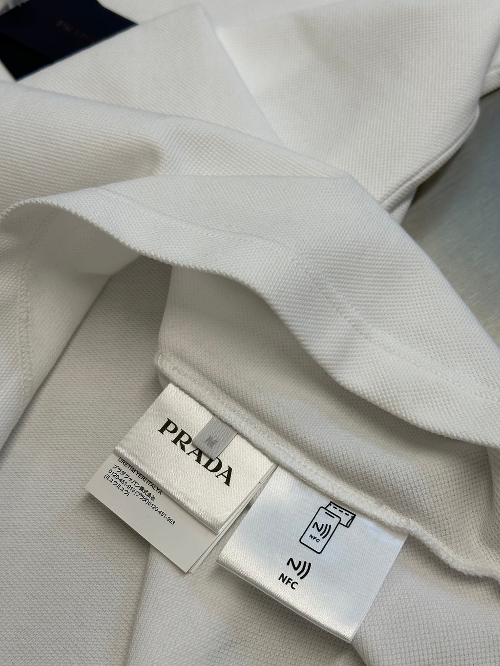 Polo shirt interior view with PRADA label and care tags