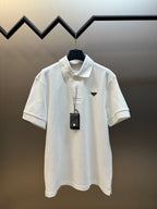 White polo shirt with short sleeves, button placket, and pointed logo badge