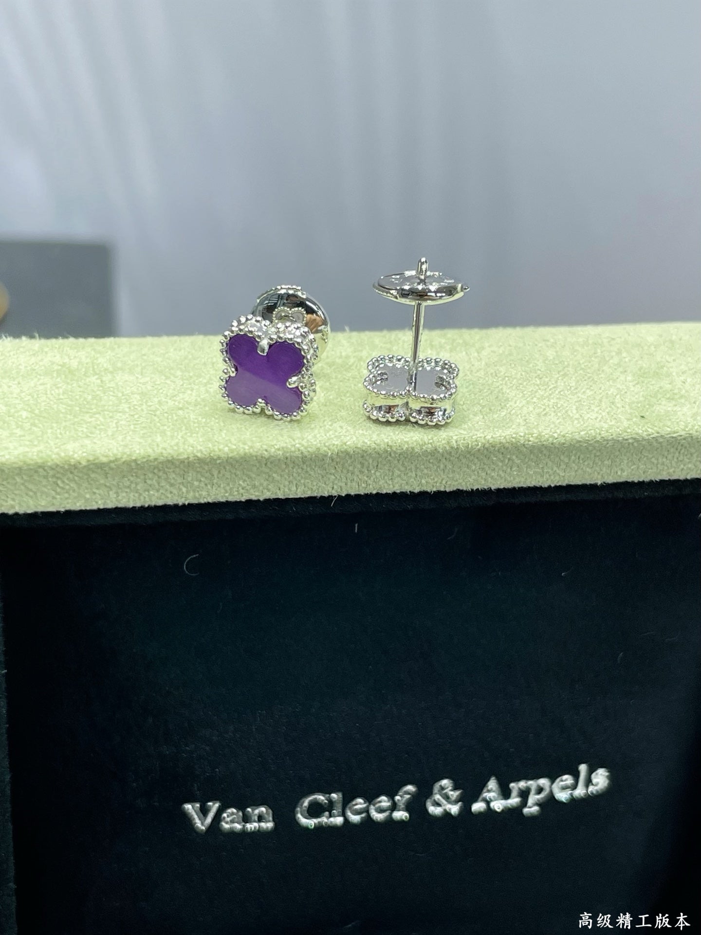 Purple clover stud earrings with silver-tone posts in Van Cleef & Arpels box