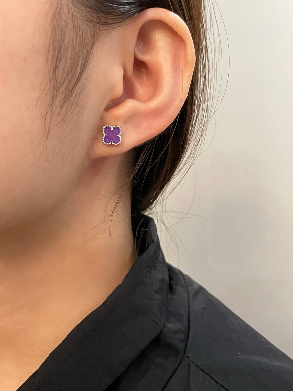 Purple clover stud earring on ear with silver-tone border
