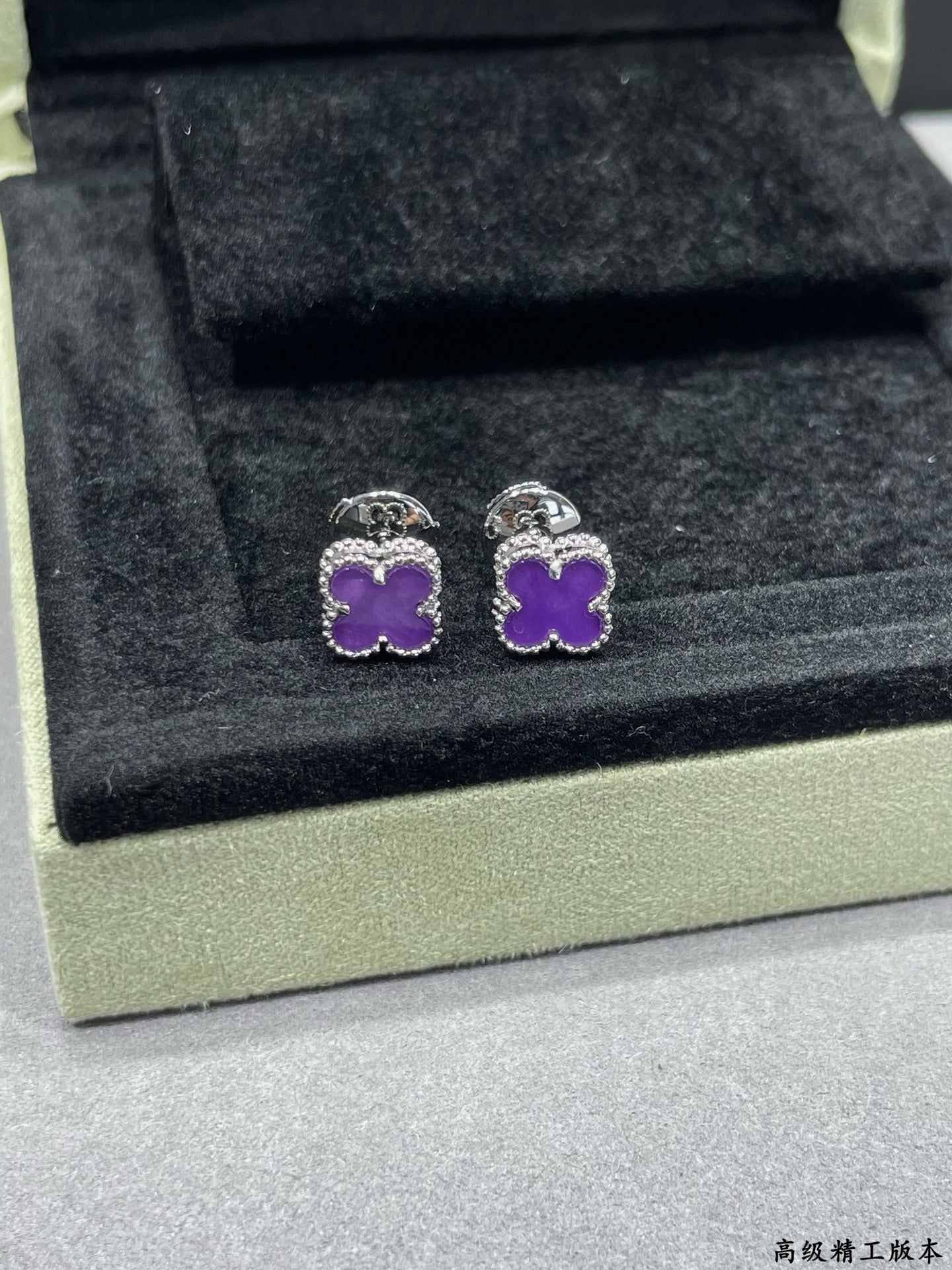 Purple clover stud earrings with silver-tone frames in jewelry box