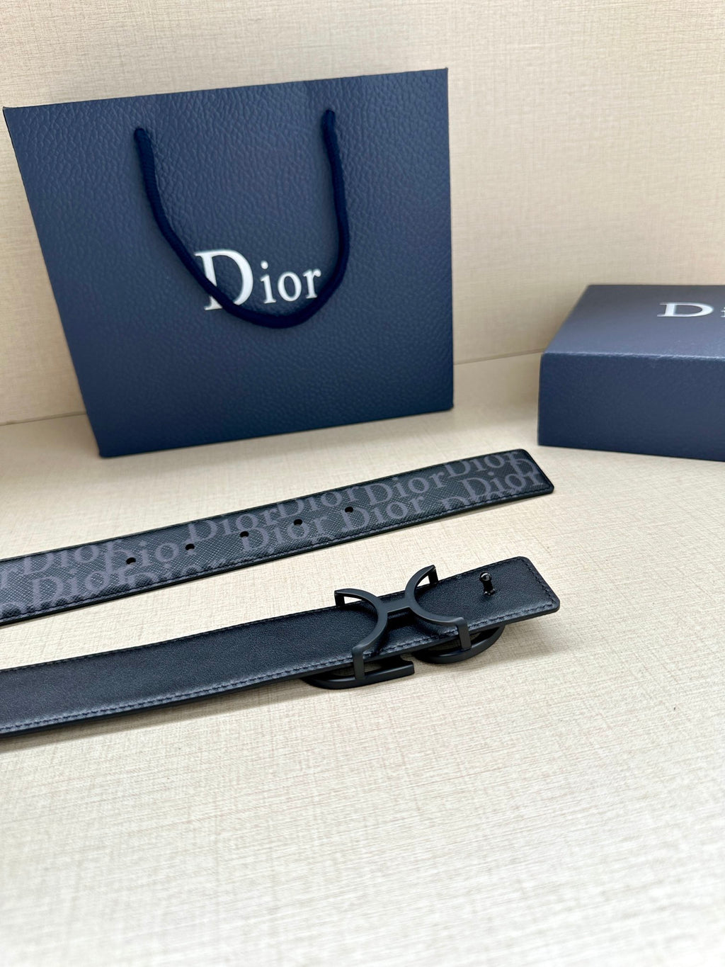 Wide navy Dior monogram belt with metal buckle and punch-hole strap