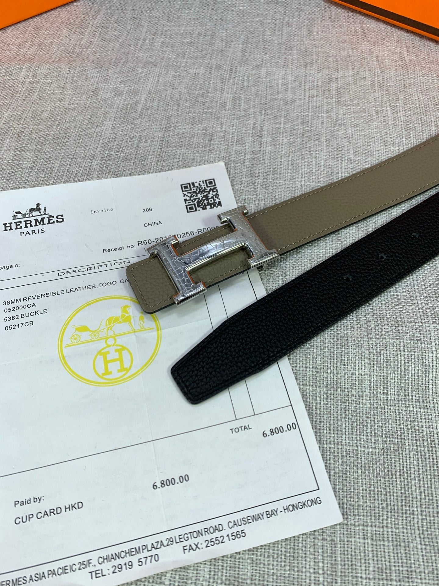 Olive leather belt detail: silver buckle with adjustable holes on the strap.