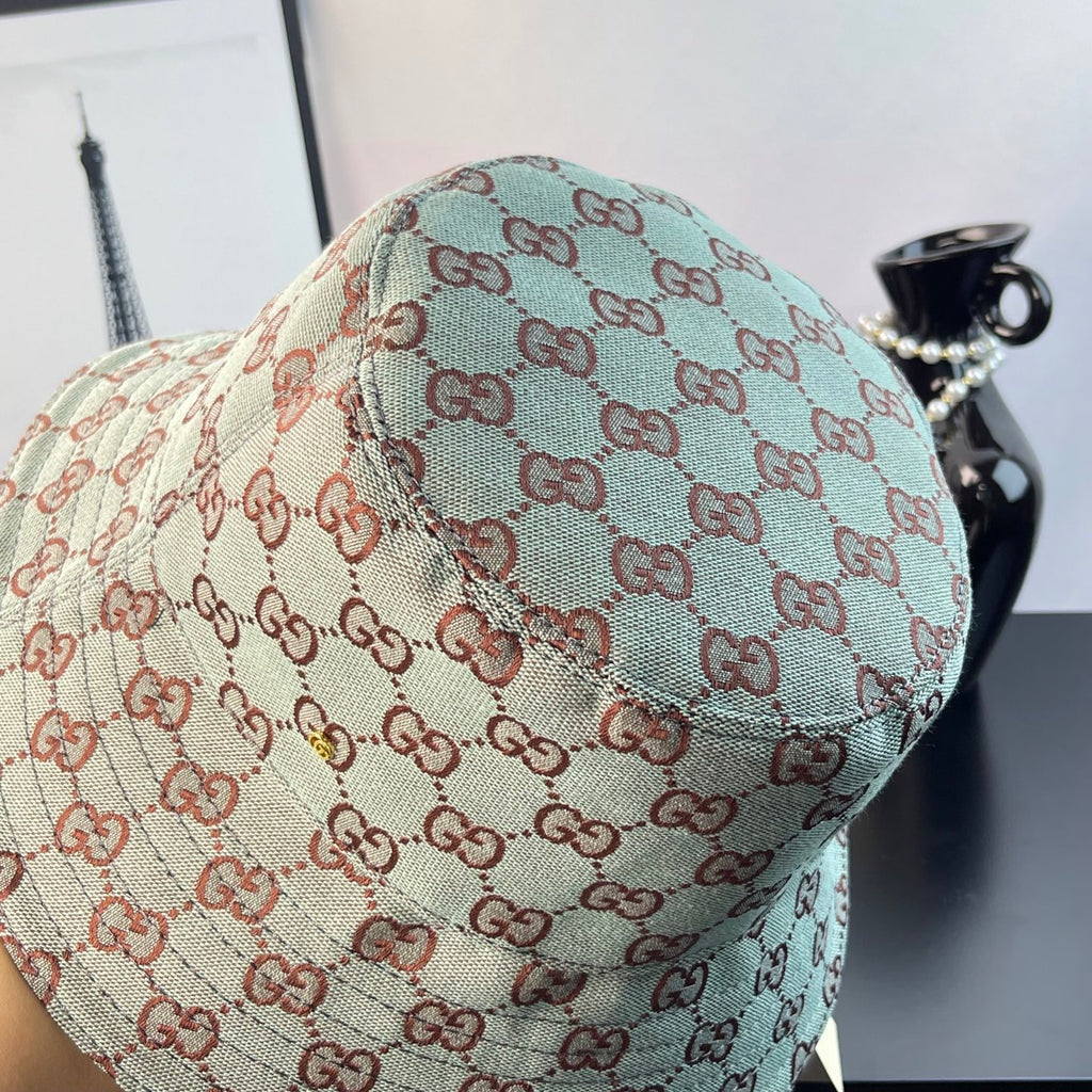 Bucket cap side view with GG monogram print in teal and cream with red-brown