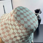 Bucket cap side view with GG monogram print in teal and cream with red-brown