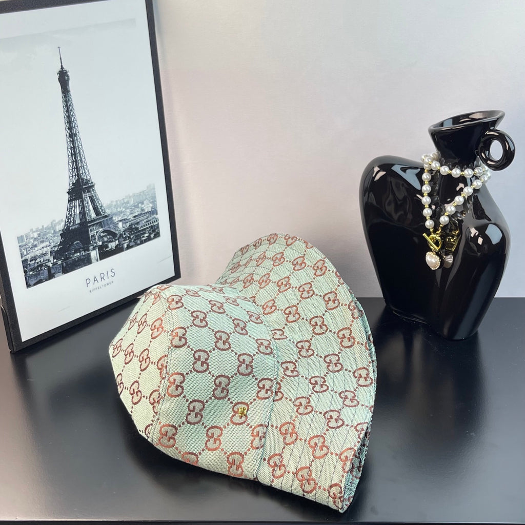 Bucket cap side view with GG monogram print in teal and cream with red-brown
