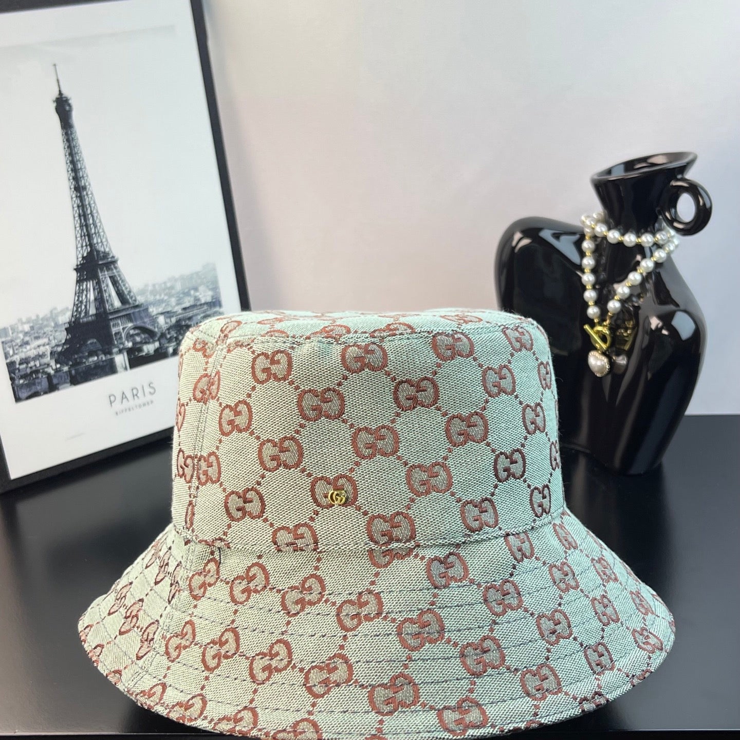 Bucket cap with GG monogram pattern in teal and cream with red-brown outline