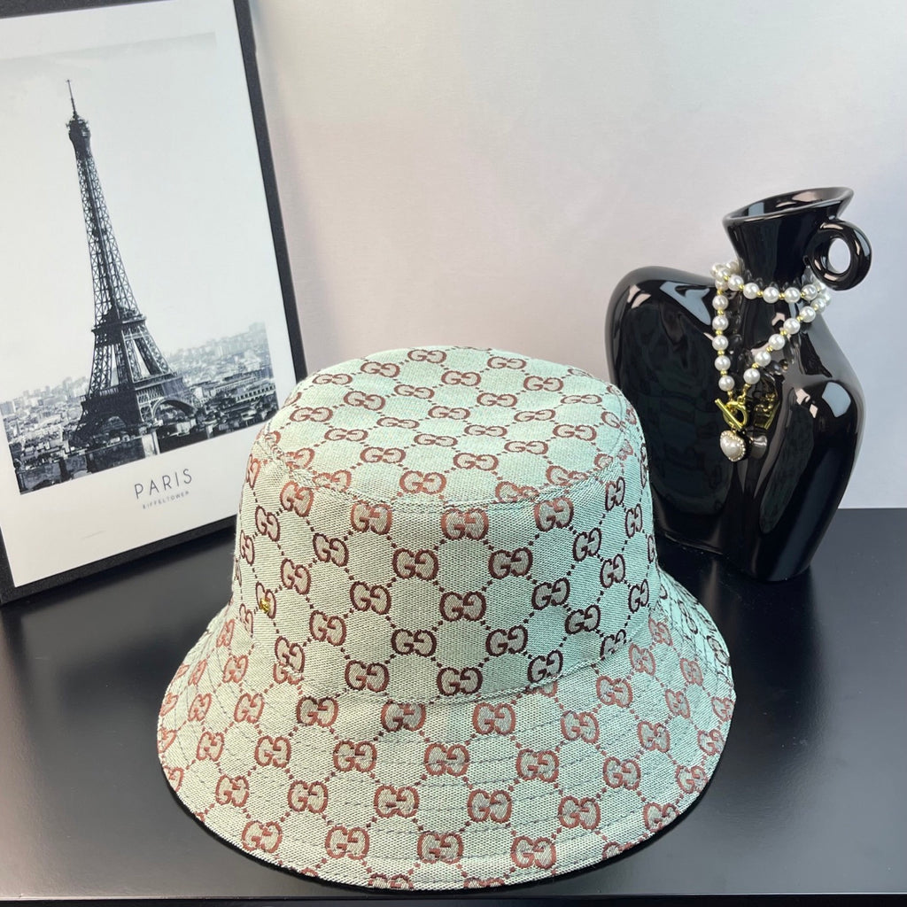 Bucket cap with allover GG monogram print in teal, cream, and red-brown tones