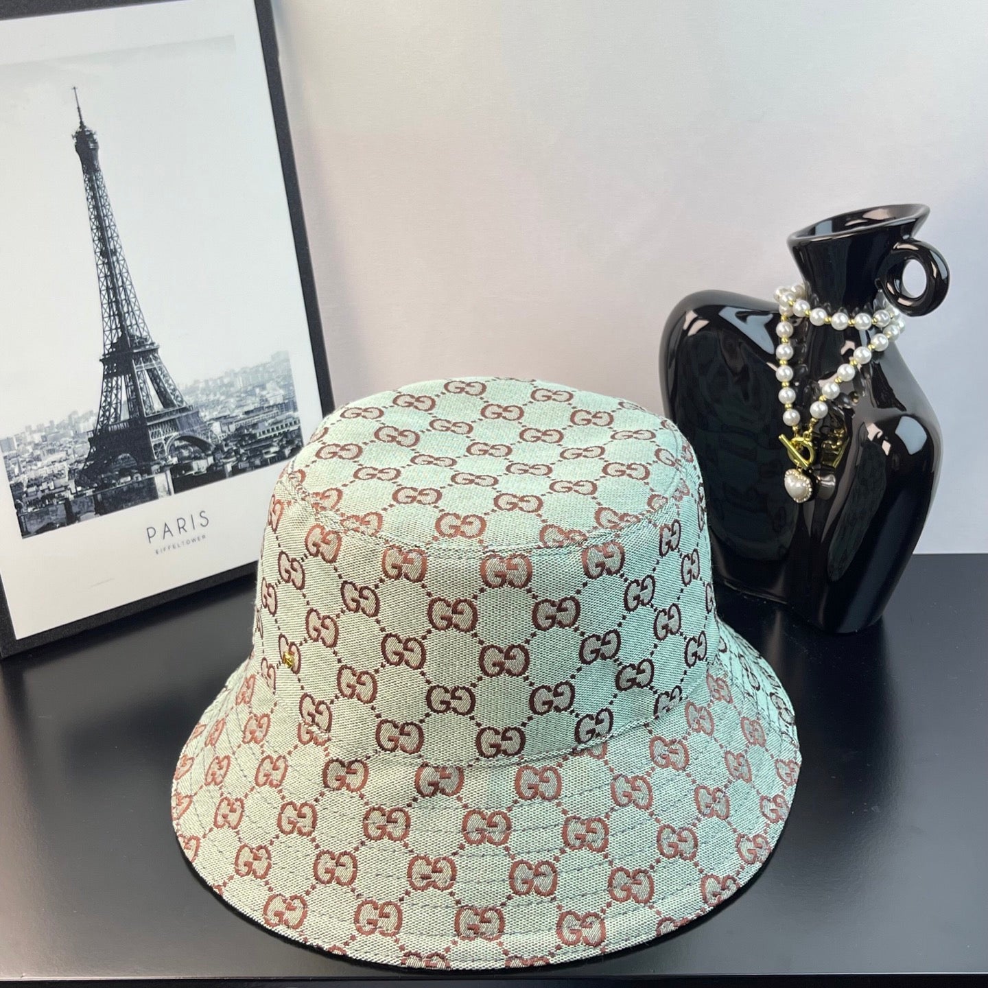 Bucket cap with allover GG monogram print in teal, cream, and red-brown tones