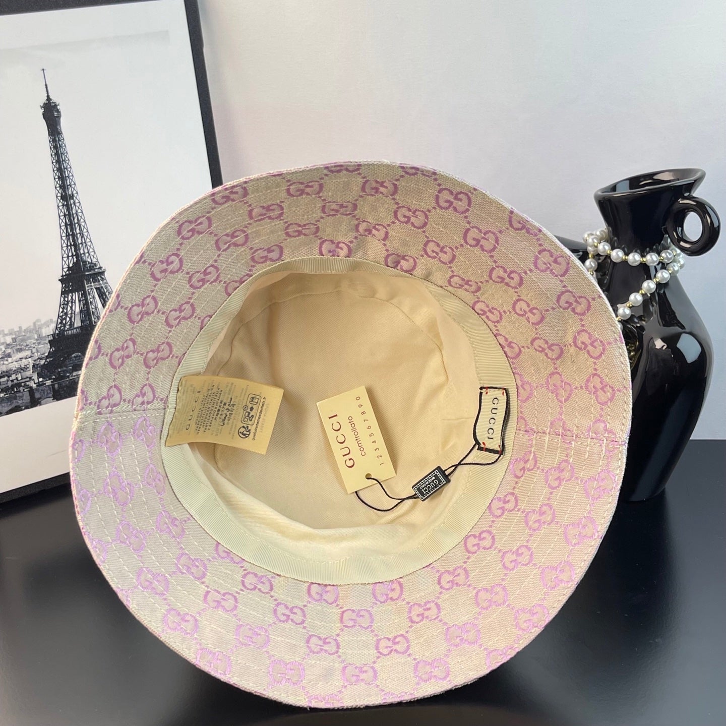 Gucci GG monogram bucket hat showing tan interior lining and hanging tags
