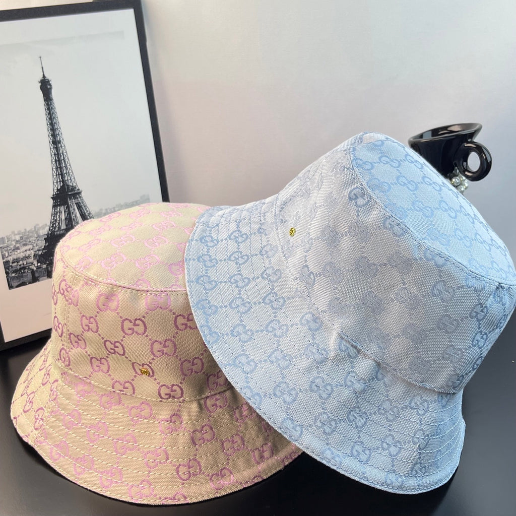 Two monogram bucket hats: pink and light blue GG patterns with curved brims
