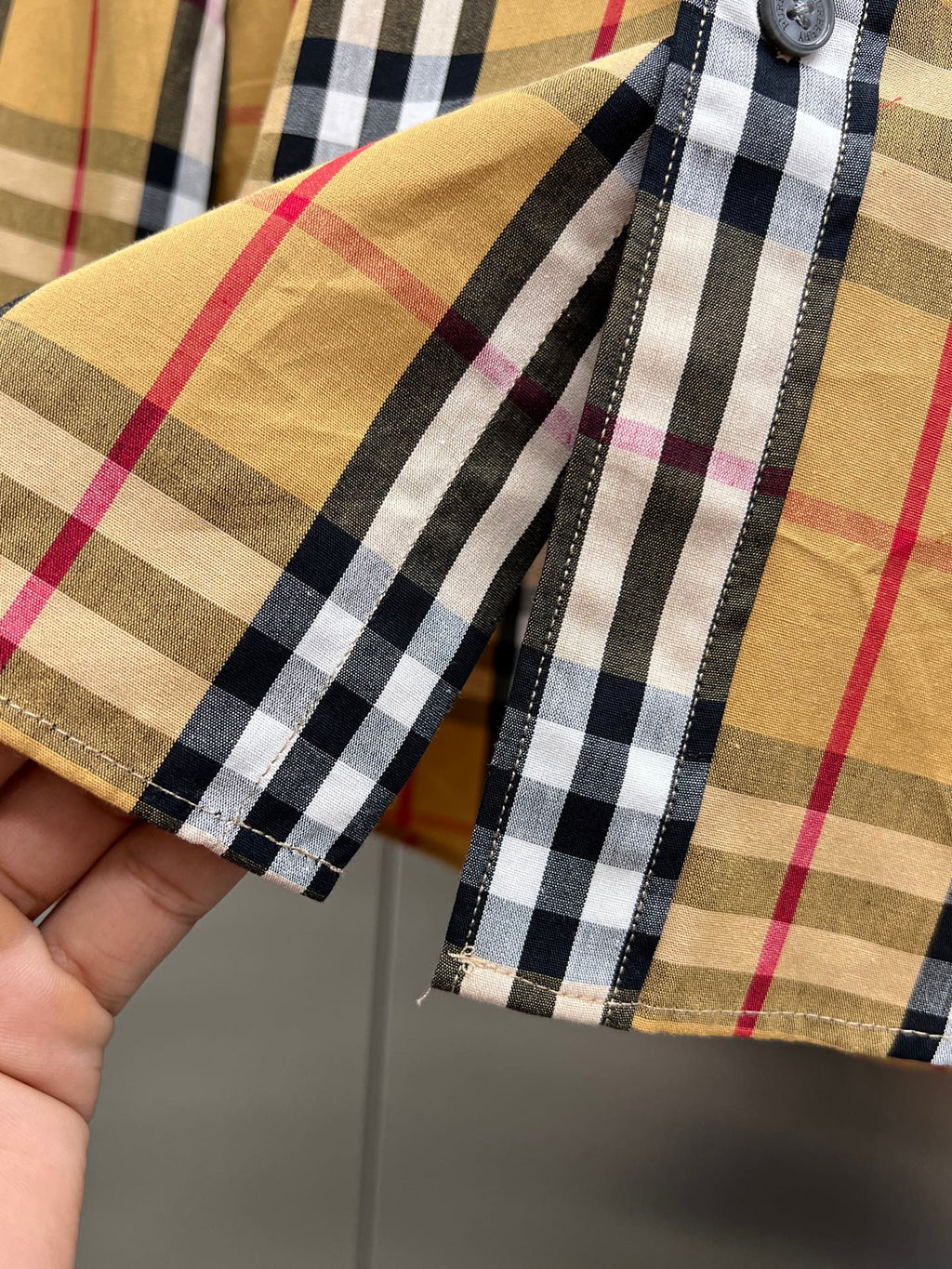 Plaid shirt cuffs with two button placket and stitched edge