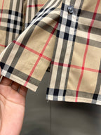 Burberry plaid shirt sleeve cuff with button, close-up on fabric stitching