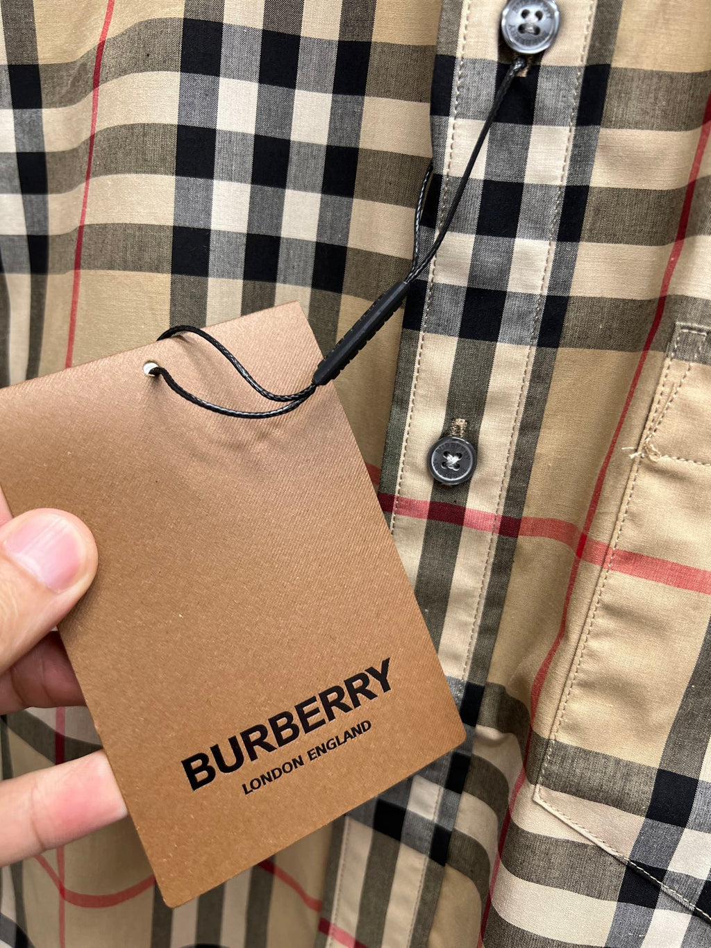 Burberry plaid shirt hang tag attached near button placket