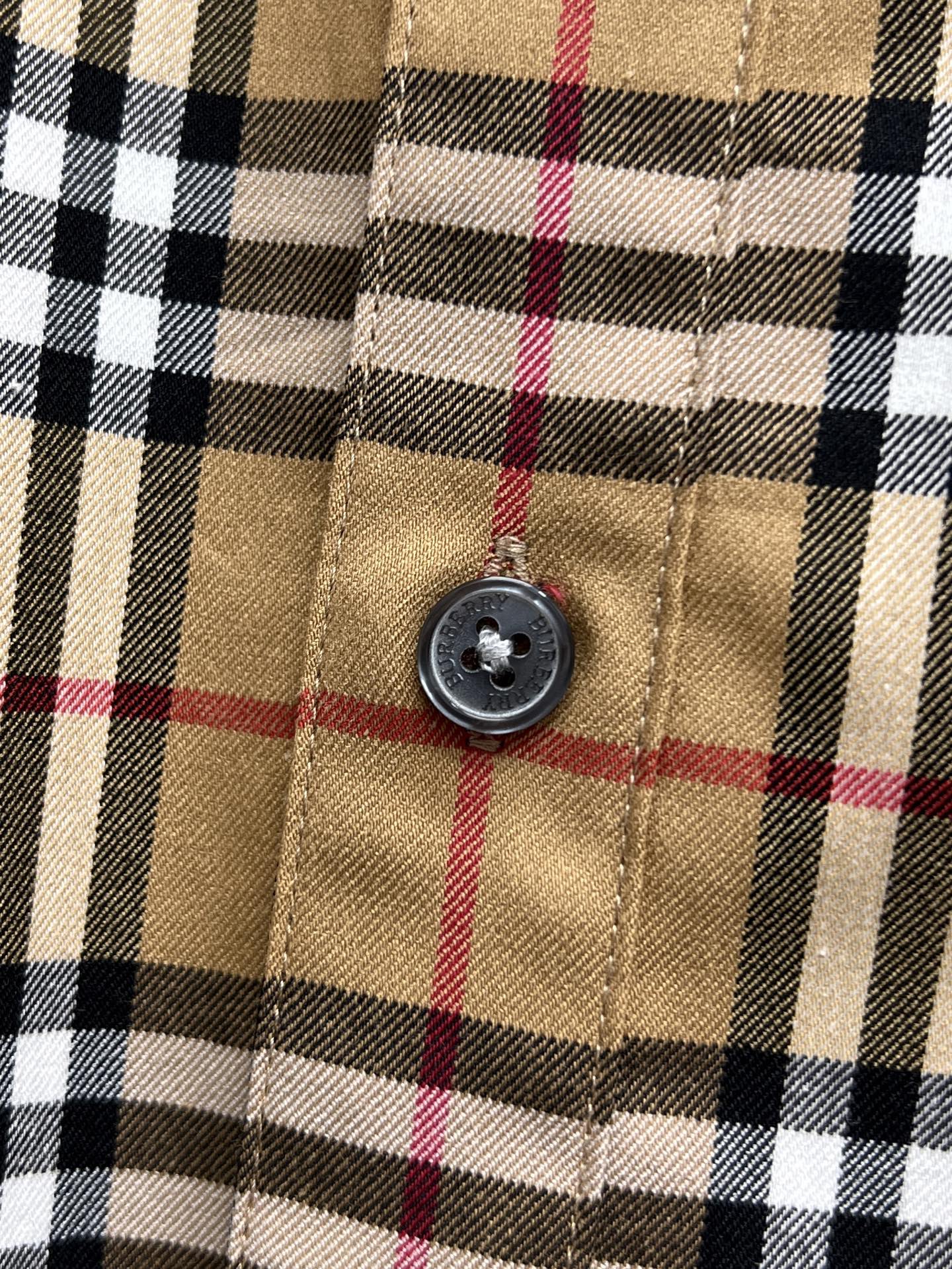 Burberry check shirt button close-up on plaid fabric