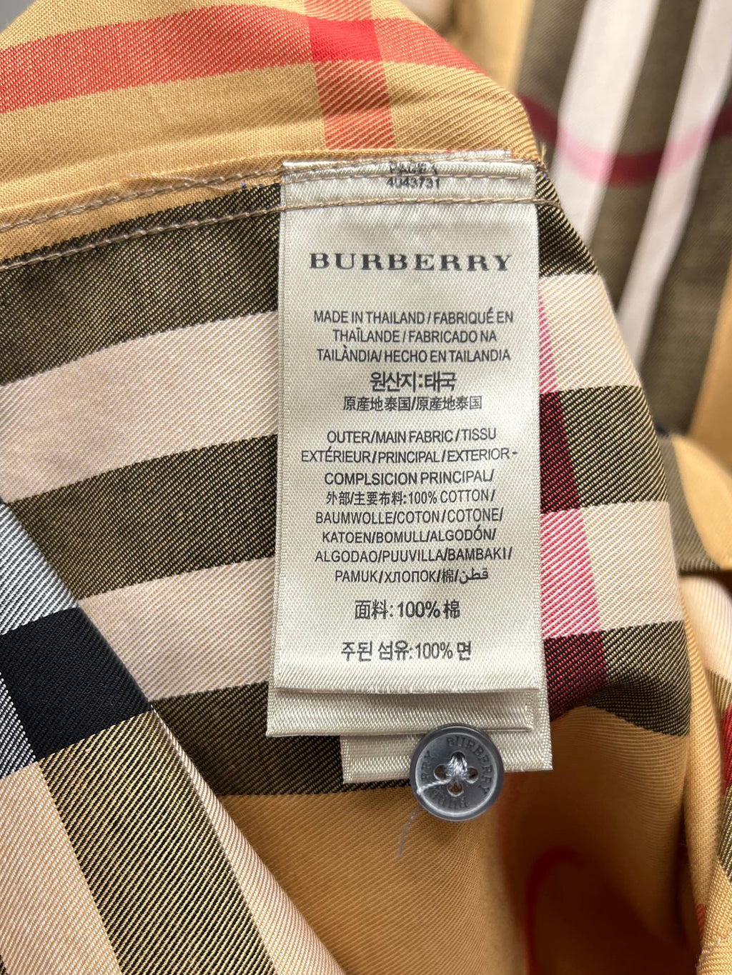 Burberry check shirt care label with fabric composition and round button