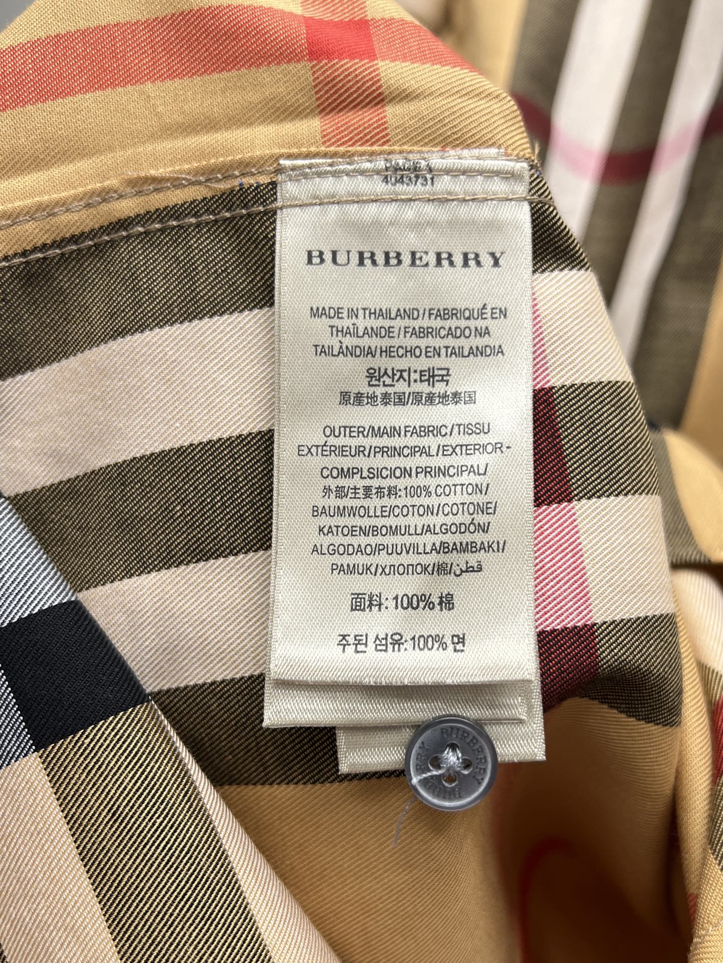 Burberry check shirt care label with fabric composition and round button