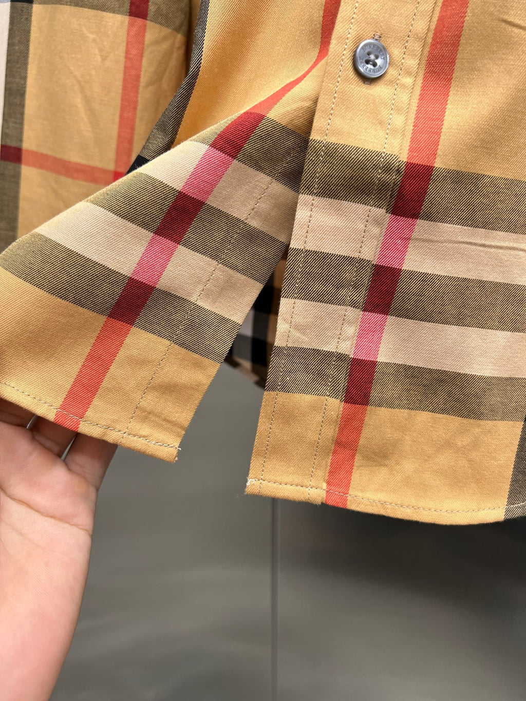Burberry check shirt sleeve cuff close-up with button fastening