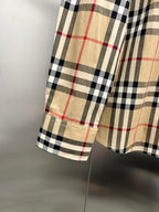 Burberry plaid shirt cuff hem detail, tan sleeve with black and red check pattern
