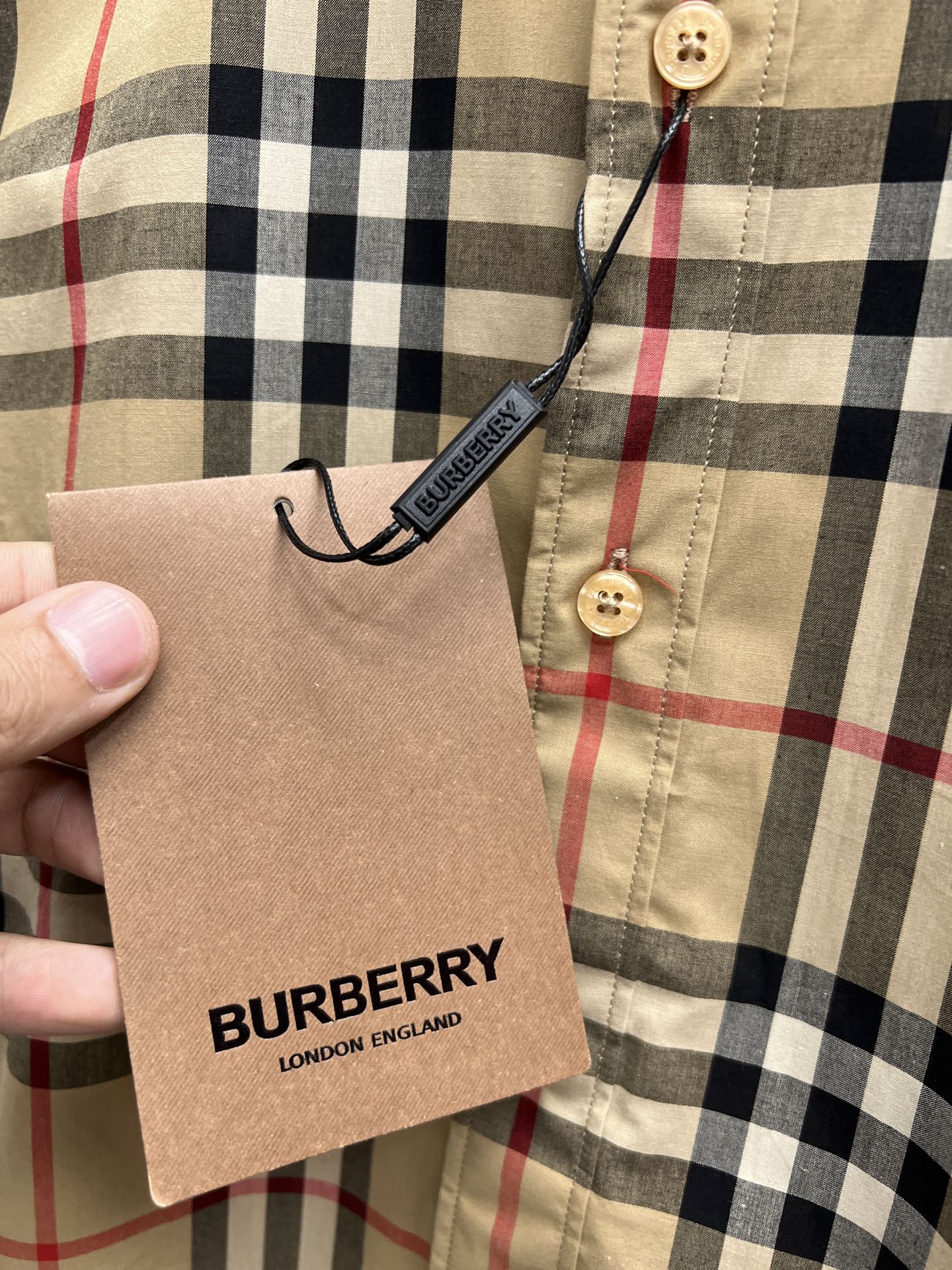 Burberry plaid shirt front hem with brand hang tag, tan with black and red check