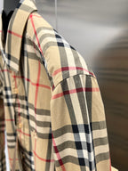 Burberry plaid shirt sleeve close-up, tan fabric with black and red stripe checks
