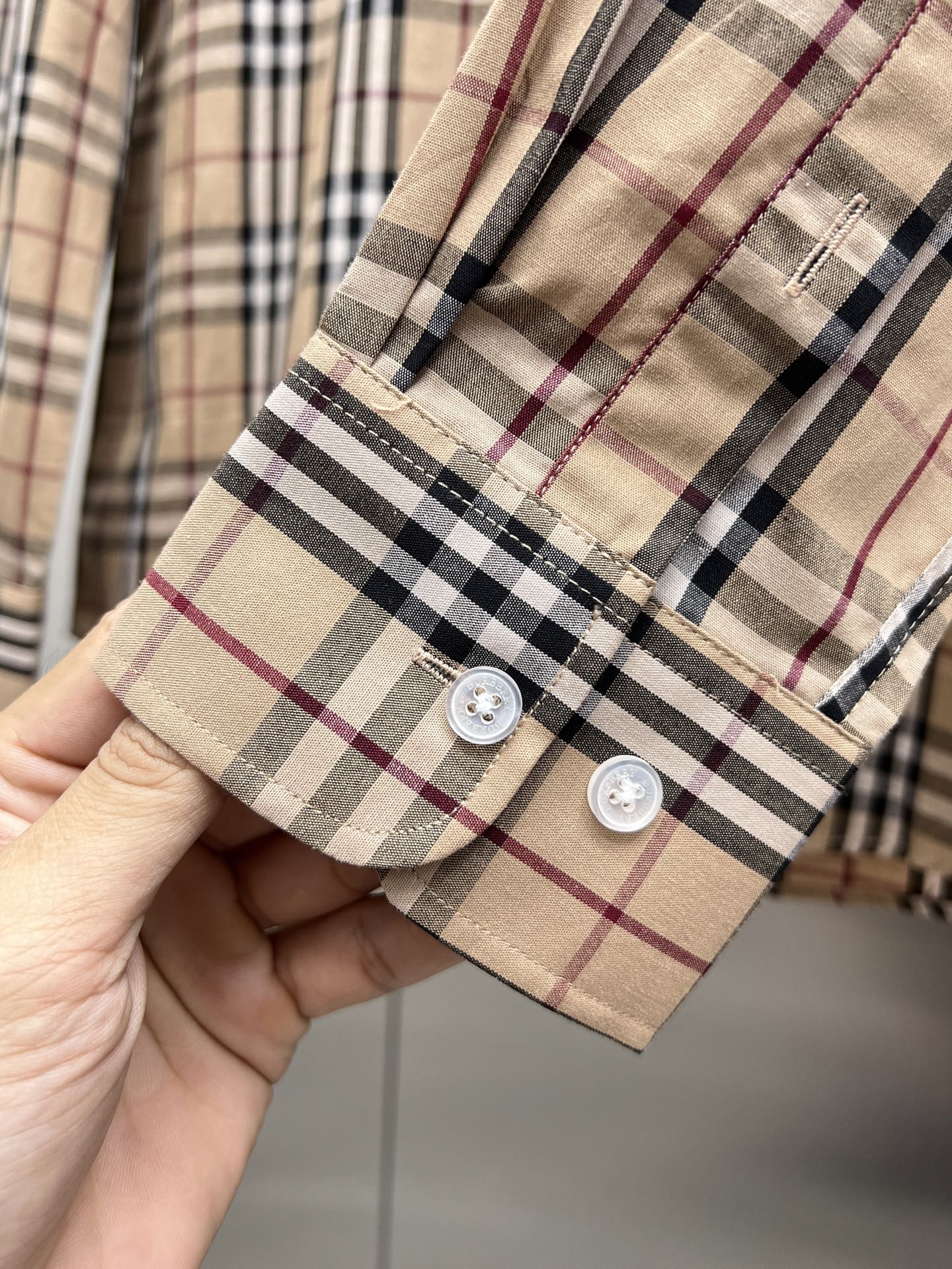 Plaid long-sleeve shirt cuff with two white buttoned plackets