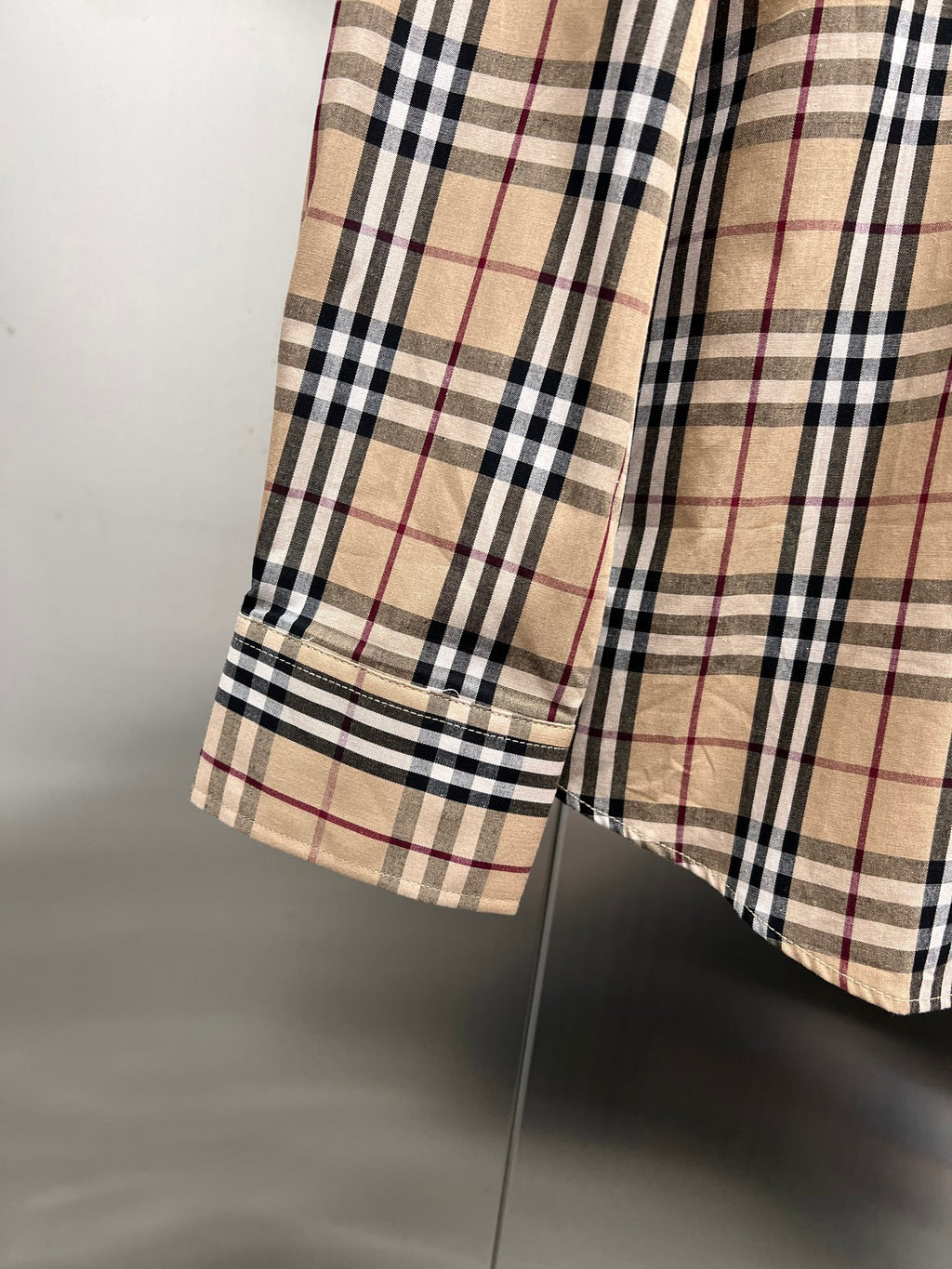 Plaid shirt hem detail with side seam and layered fabric panel
