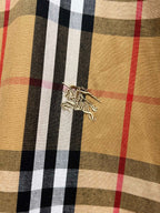 Plaid shirt fabric close-up with decorative embroidered strap detail on chest